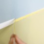 Anwendung von Tesa Malerband Professional für präzise Farbkanten beim Malen.