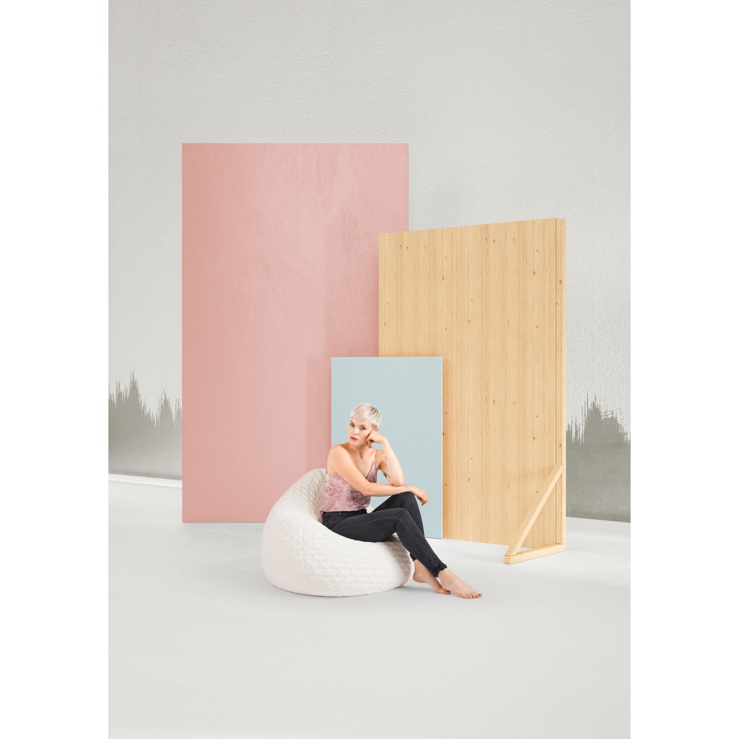 Frau sitzt im weißen Sitting Point Sitzsack BeanBag Fluffy mit Herzmuster.
