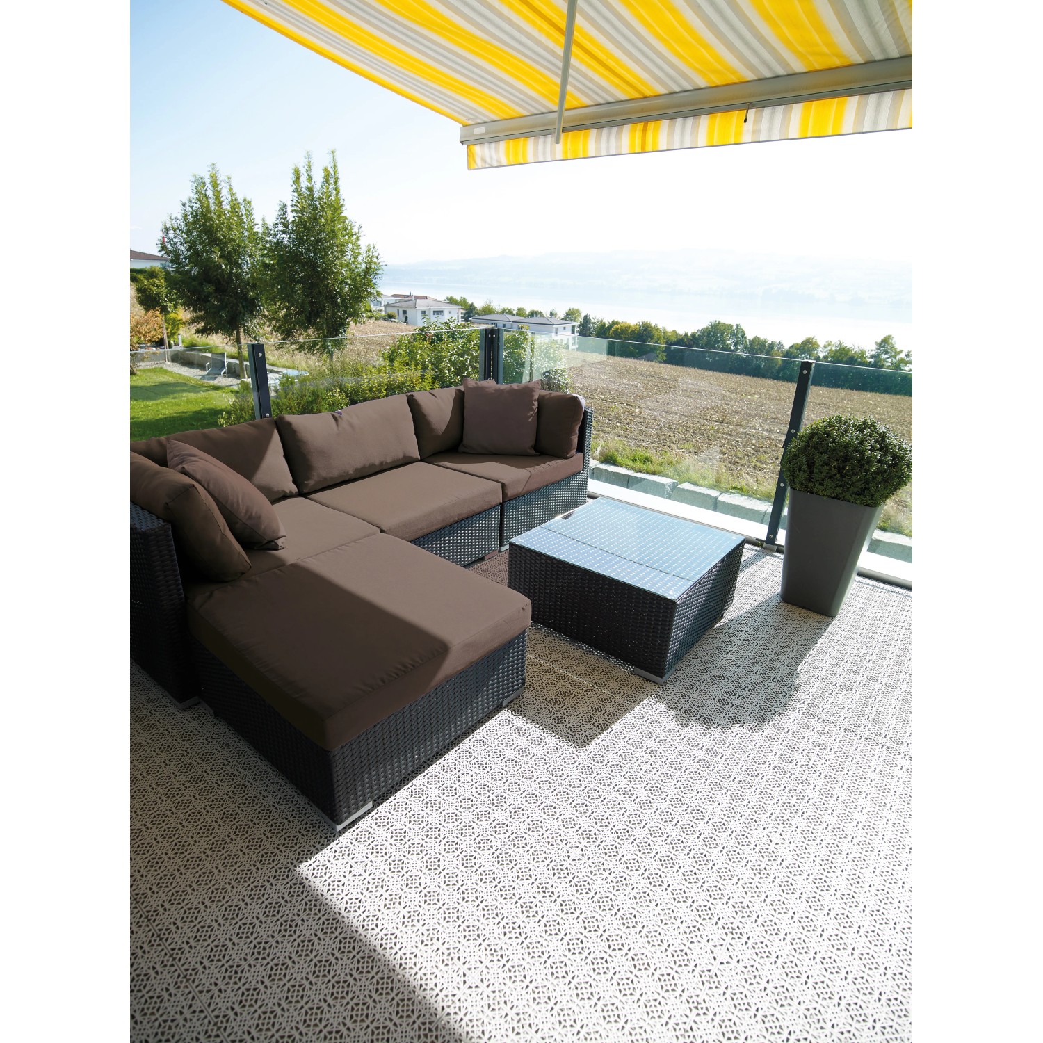 Verlegte Andiamo Klick-Fliese Hellgrau (7 Stück) auf einer Terrasse mit Lounge-Möbeln.