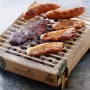 Einweg Casus Grill mit Würstchen und Fleisch auf dem Grillrost.