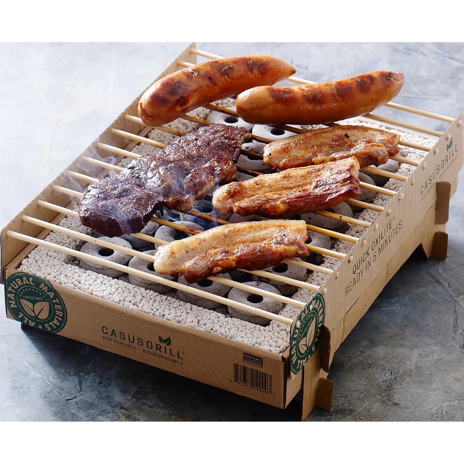 Einweg Casus Grill mit Würstchen und Fleisch auf dem Grillrost.