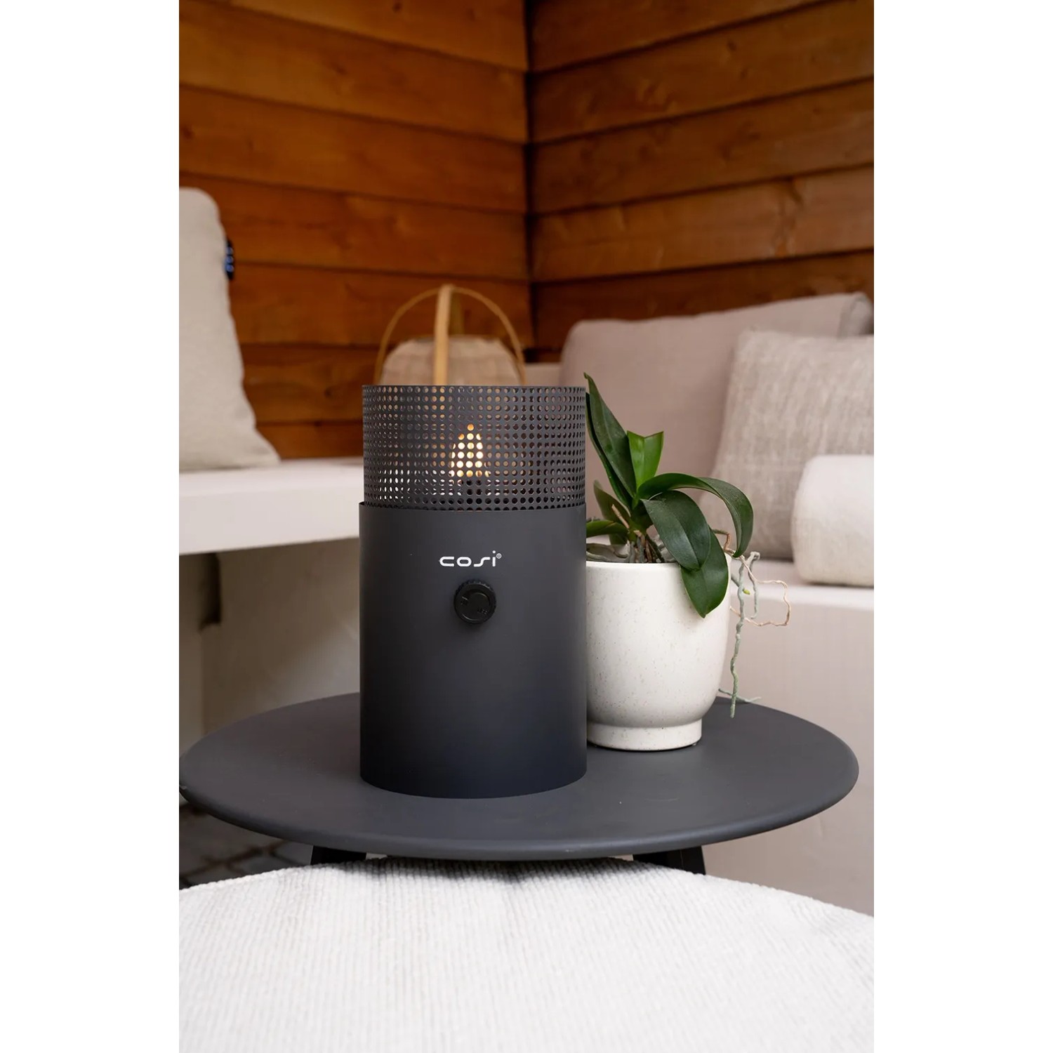 Anthrazitfarbene Cosi Gaslaterne Cosiscoop Dot (Ø 16 x 27 cm) auf Tisch, mit Flamme.