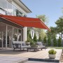 Orange-braune Wismar Gelenkarmmarkise Classic, 300x200 cm, montiert an einer Hauswand über einer Terrasse.