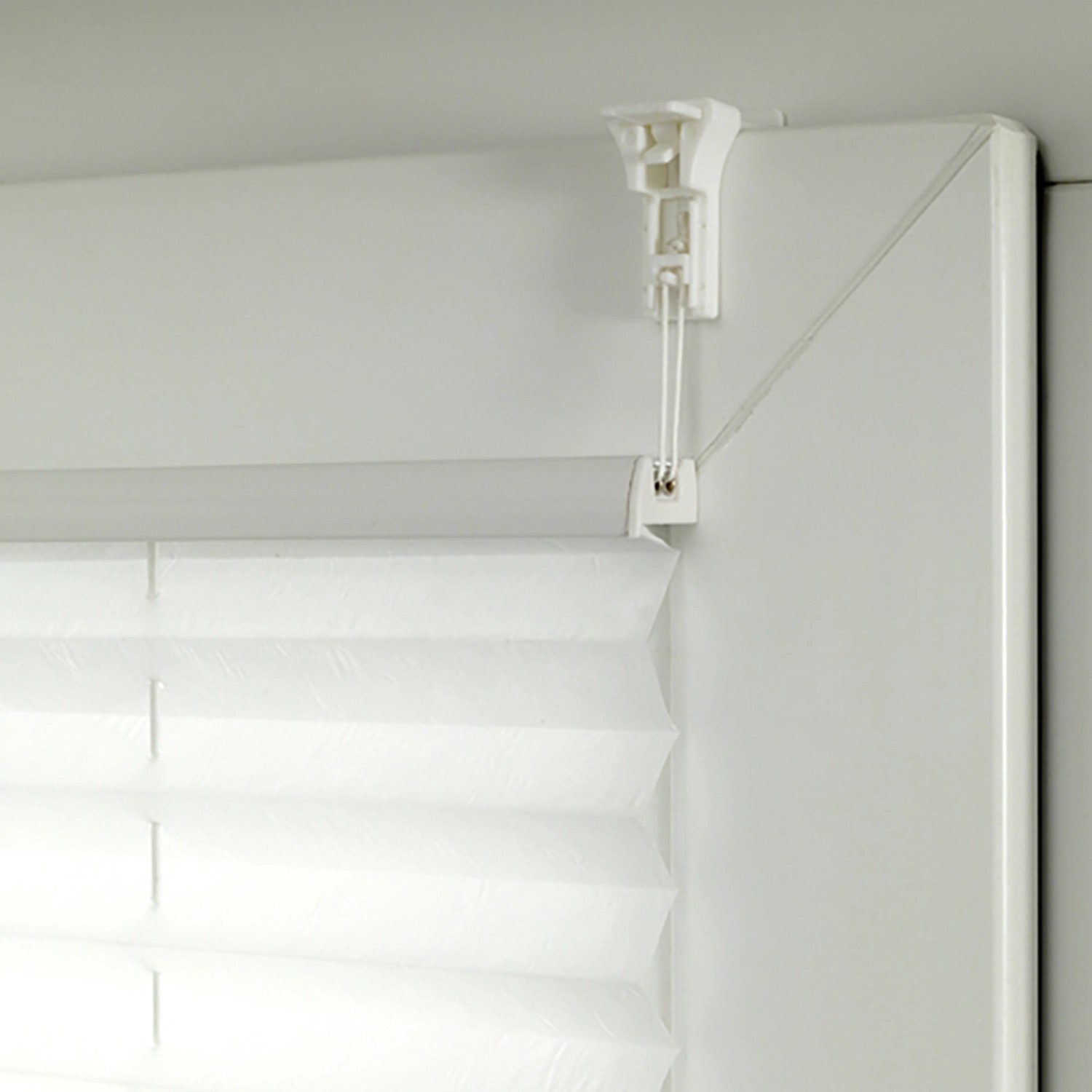 Detailaufnahme: Weißes Gardinia Plissee Bella Blätter am Fenster mit Klemmträger.