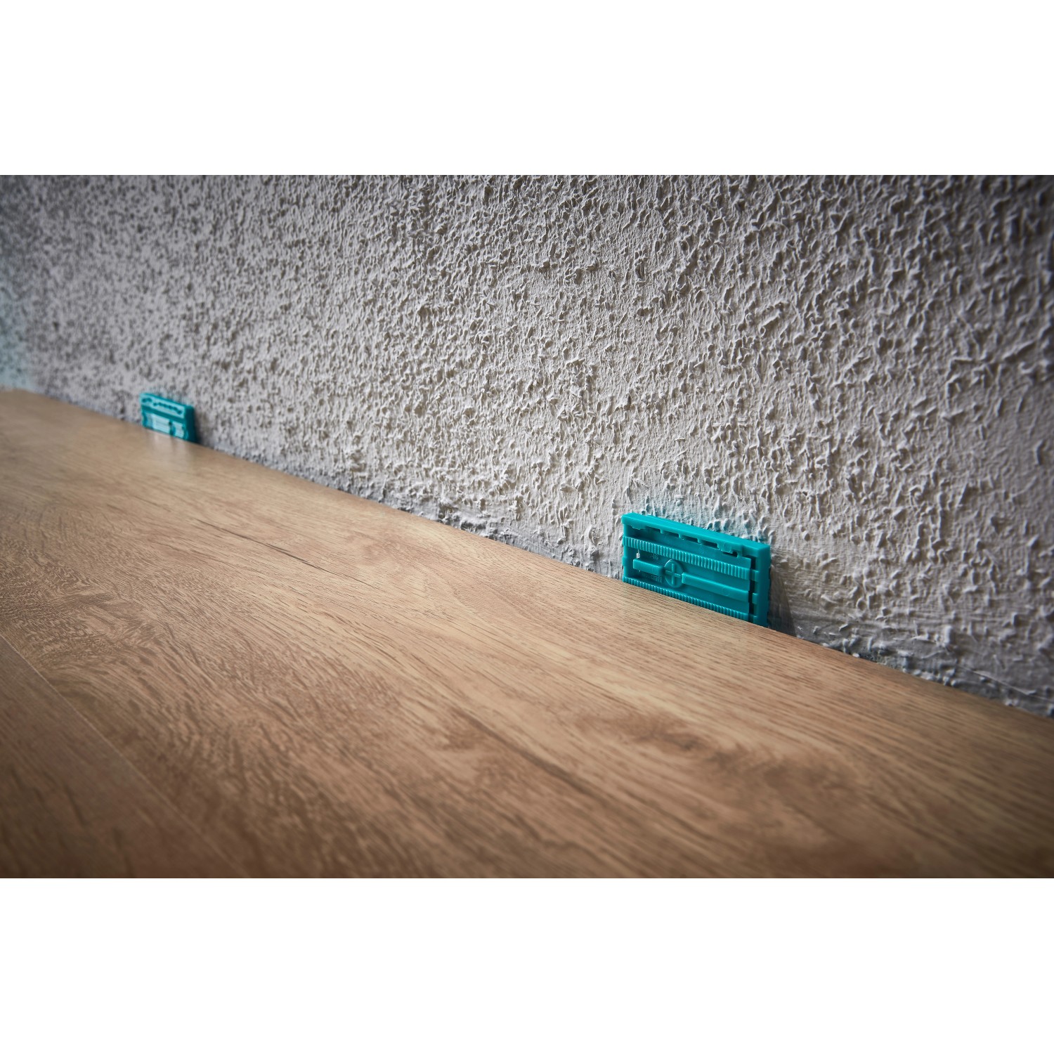 Verlegung von Laminat mit Keilen aus dem wolfcraft Verlege-Set für Laminat- und Designboden.