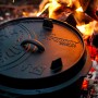 Schwarzer Petromax Dutch Oven FT9 (7,5 l) mit Deckel im Feuer. Ideal zum Kochen und Backen im Freien.