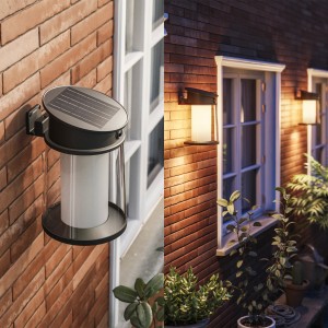 Philips Juda Solar Wandleuchte, schwarz, mit Solarpanel an einer Backsteinwand.