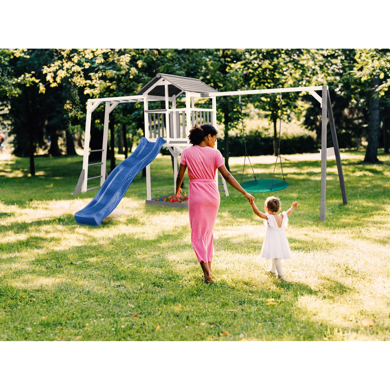 Axi Beach Tower Spielturm mit Rutsche, Nestschaukel und Klettergerüst im Garten.