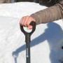 Gardena ClassicLine Schneeschieber mit Hand am Griff vor Schneehaufen.