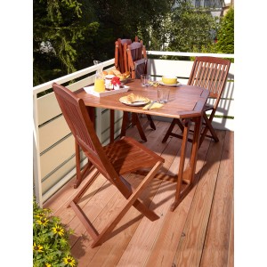 Rechteckiger, brauner Gartentisch Greenville (100x92cm) aus FSC®-Holz mit Stühlen auf einem Balkon.