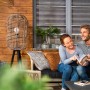 Paar entspannt auf Terrasse mit Xyladecor Holzschutz-Lasur behandeltem Holz.