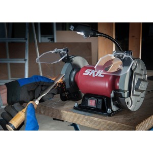 Skil Doppelschleifer 1355AA in Aktion mit Werkstück, Funkenschutz und LED-Leuchte.