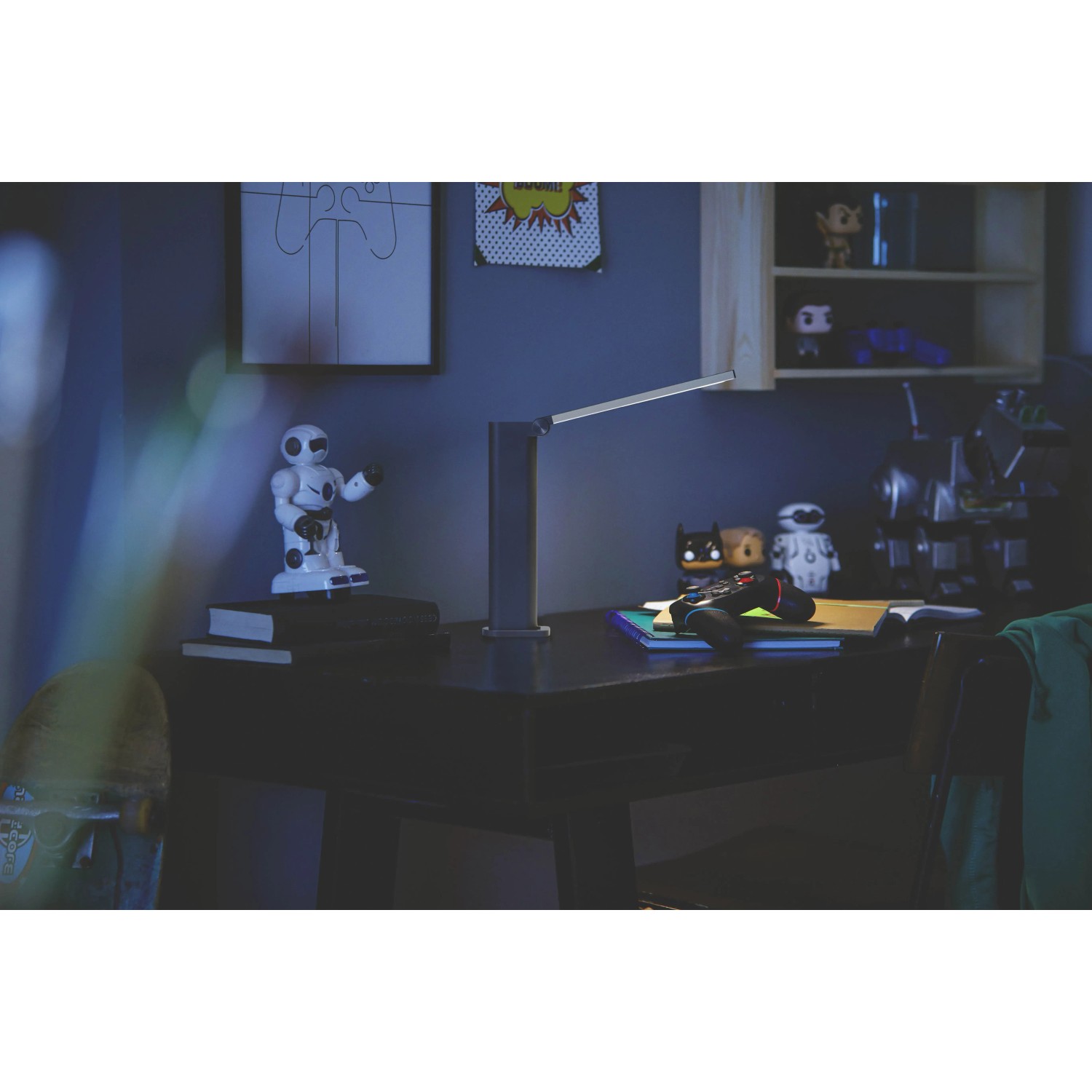 Schwarze Philips LED-Tischleuchte Amber mit Akku auf Schreibtisch mit Deko.