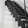 Schwarze Minka Raumspartreppe Modulario Mini Steel mit Stahlgeländer vor weißer Wand.