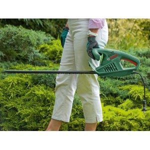Bosch EasyHedgeCut 60 Elektro-Heckenschere in Aktion beim Heckenschnitt.