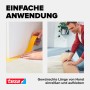 Hände reißen tesa Universal Doppelseitiges Klebeband ab und kleben es an; Mann fixiert Teppich. Einfache Anwendung.