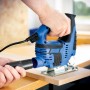 Blaue LUX Stichsäge E-STS-23 mit Staubsauger-Anschluss beim Sägen von Holz.