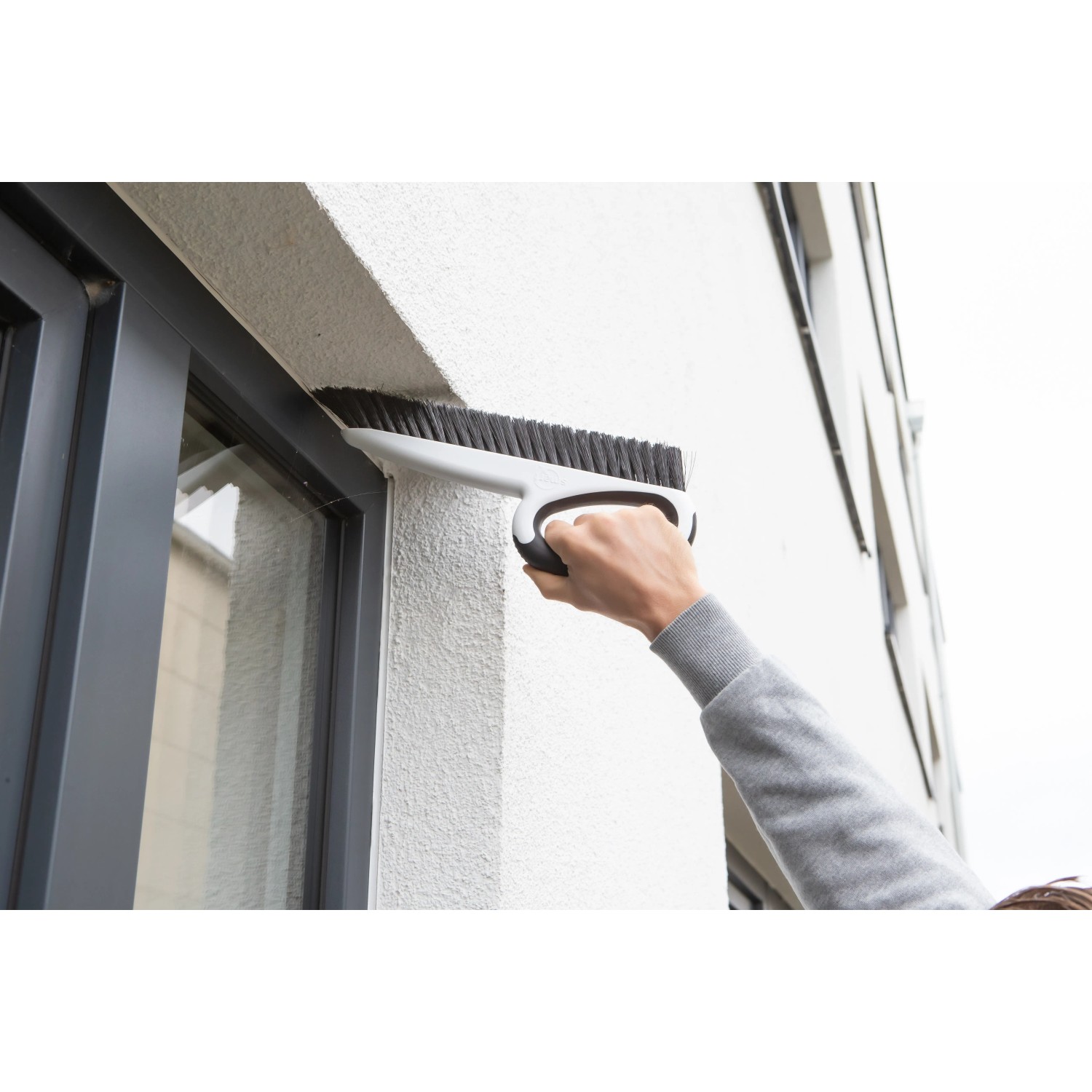 SmartQ Haushalts- & Tapezierbürste im Einsatz zum Reinigen eines Fensterrahmens.