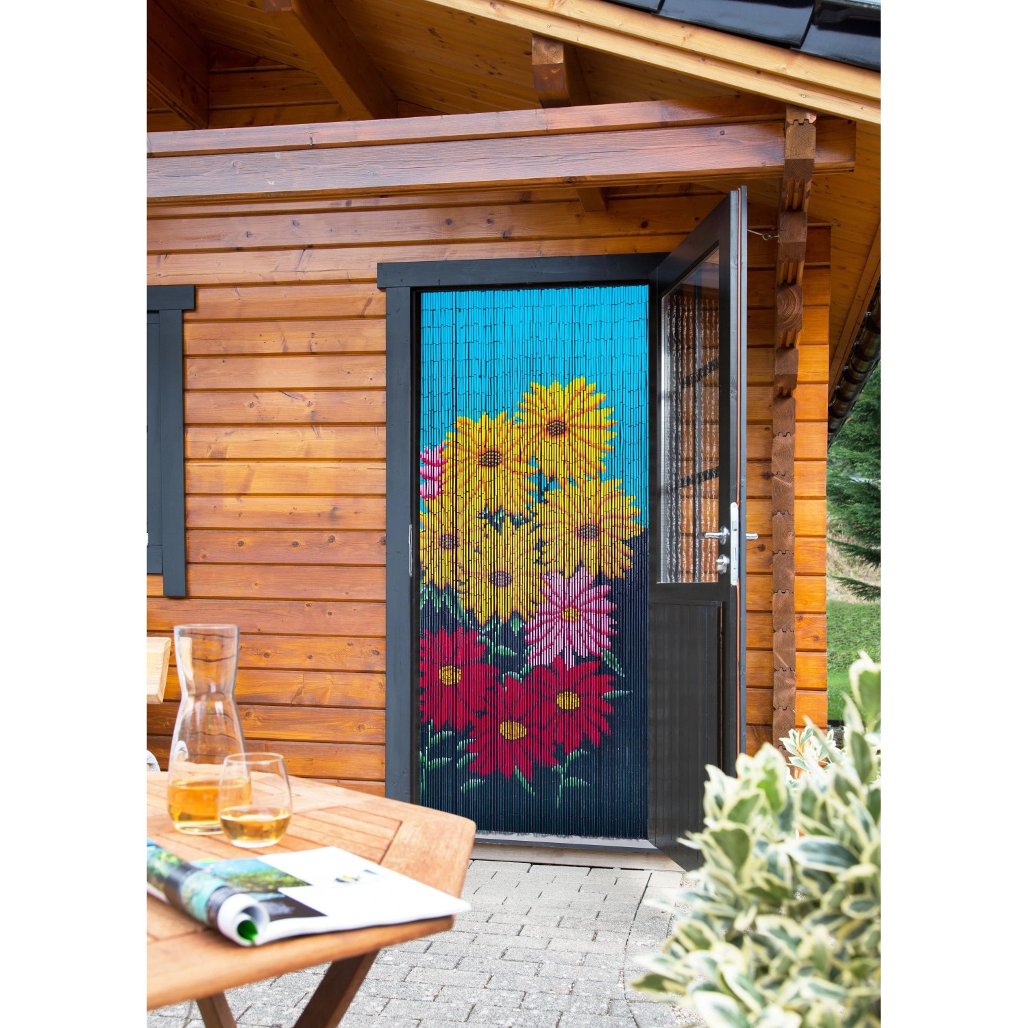 Conacord Türvorhang Flowers, 90x200 cm, Bambus mit Blumenmuster vor Holzhütte.