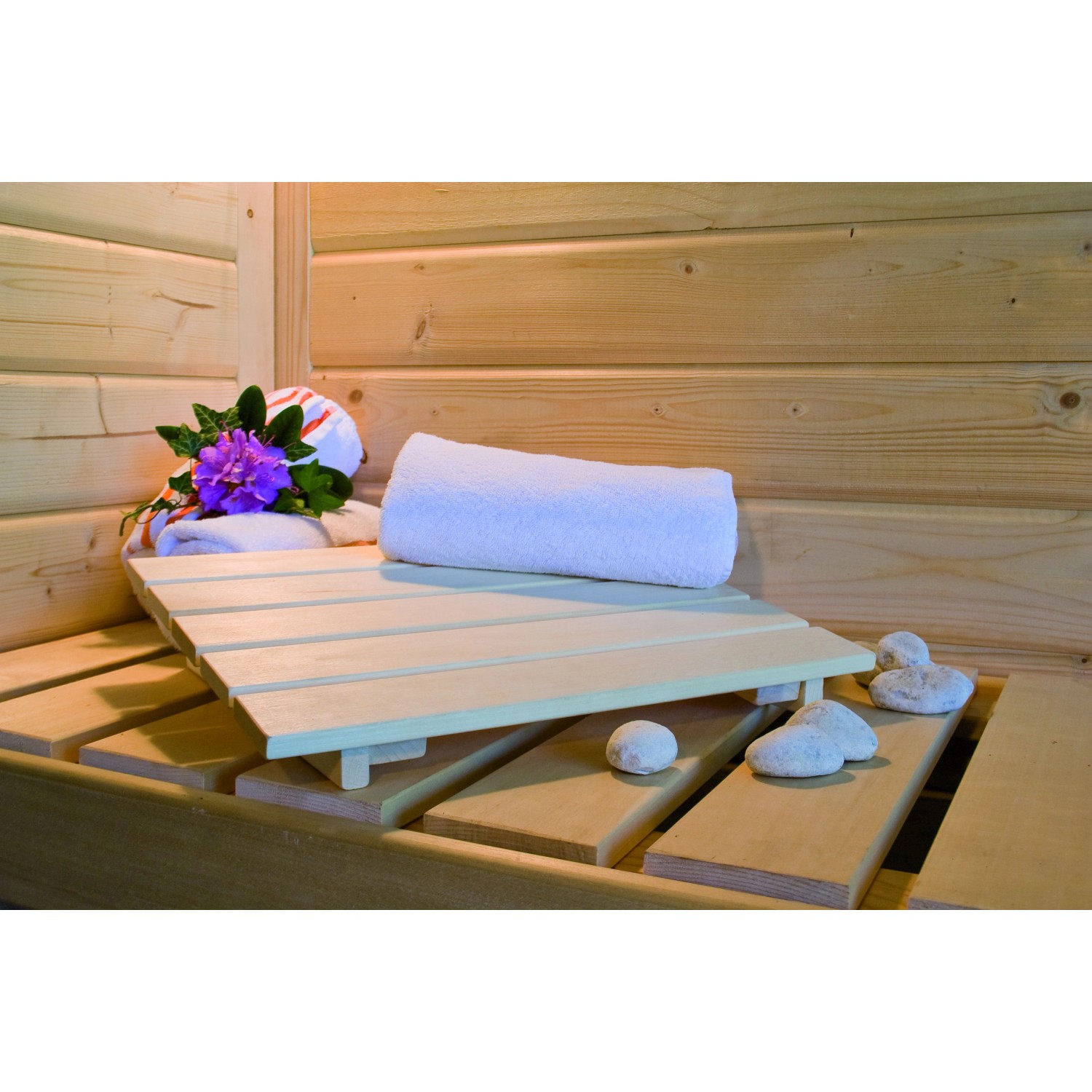Innenansicht der Karibu Sauna Oulu mit Handtuch, Blume und Steinen auf der Saunabank.