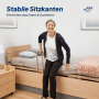 Frau sitzt auf AM Qualitätsmatratze Dekubitus Prophylaxe Pflegematratze 90x200 mit stabilen Sitzkanten.