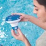Frau hält Bestway Pool Dosierschwimmer für Chemikalien zur Poolpflege über Wasser.