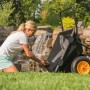 Polar Schubkarre Cub Cart, schwarz, beim Beladen mit Steinen im Garten.