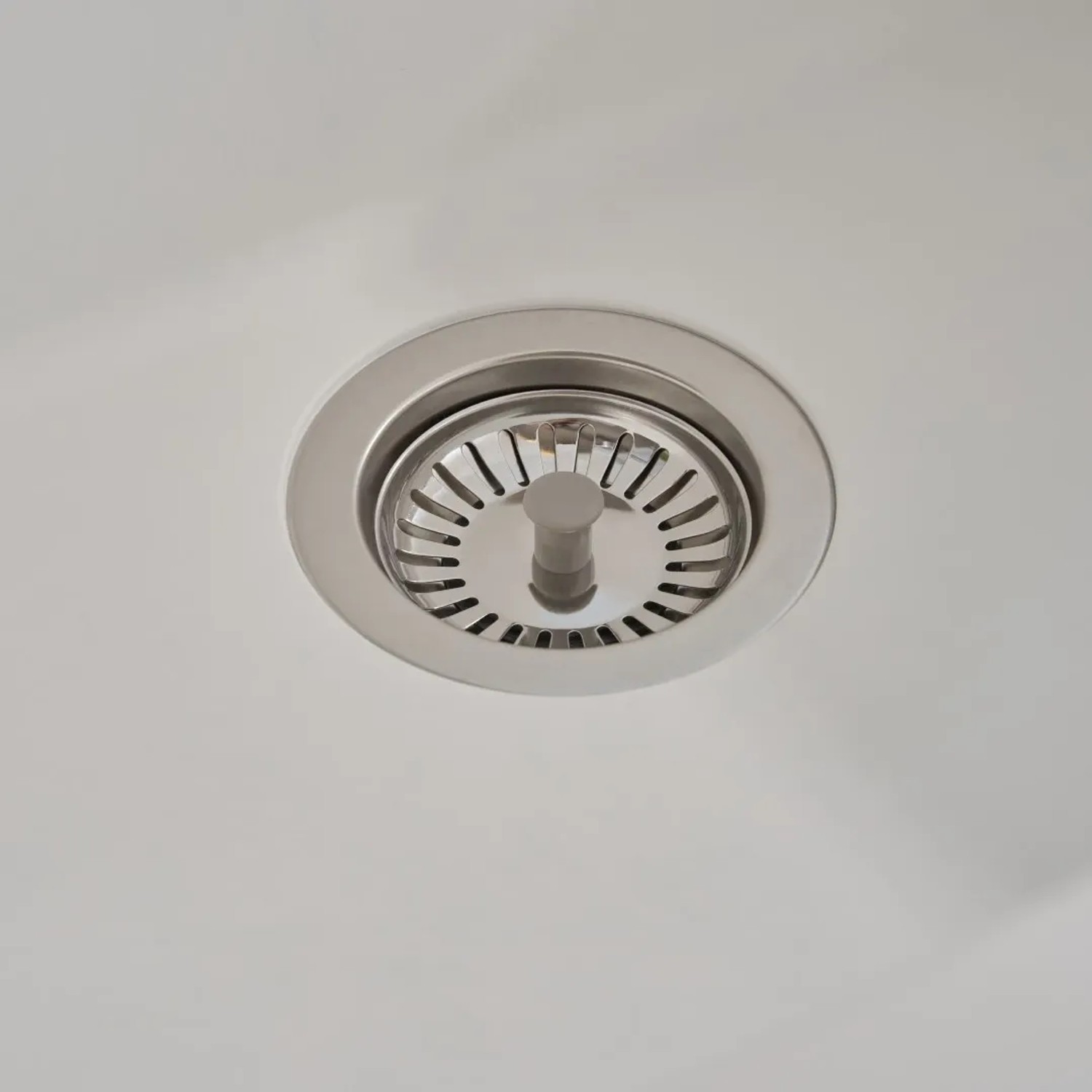 Detailaufnahme: Weißes Spülbecken Respekta Mineralite Ohio mit Siebkorb.