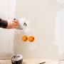 Handwerker spachtelt Wand mit Japanspachtel-Set von LUX. Werkzeug und Spachtelmasse im Einsatz.