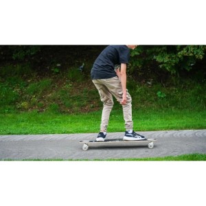 Fahrer auf Muuwmi Lights Longboard Glow Pablo mit LED-Rollen auf Asphaltweg. Sport & Fitnessgerät für Outdoor-Spaß.