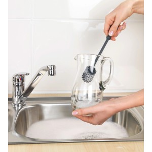 Anthrazitfarbene Wenko Silikon Spülbürste (25 cm) beim Reinigen einer Glaskaraffe in der Spüle.