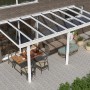Weiße Terrassenüberdachung Basic mit Glasdach, 600x300 cm, montiert an Hauswand.