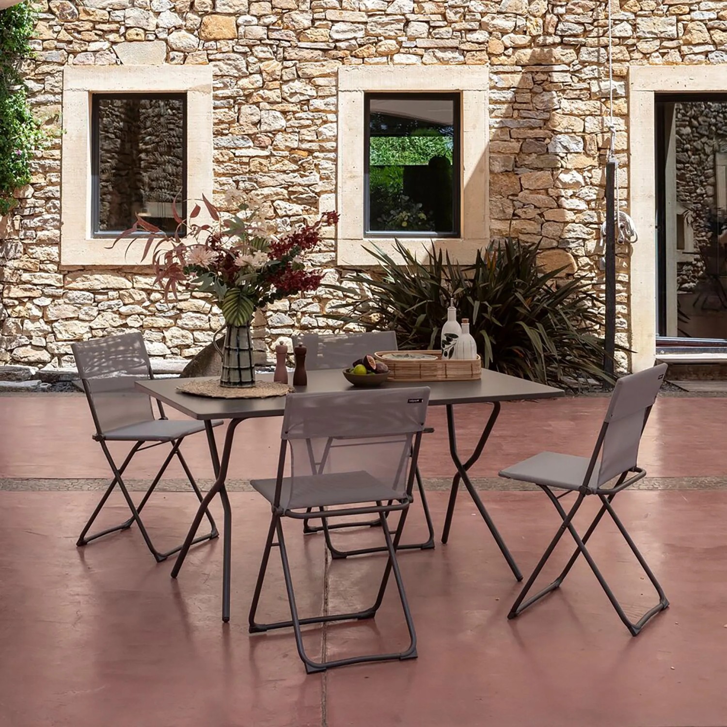 Lafuma Balkontisch Balcony, 140x80 cm, Titan, mit vier Stühlen auf Terrasse.