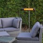 VASNER SlimLine X20 Infrarot-Heizstrahler, 2000W, schwarz, mit Fernbedienung neben Sitzgruppe.
