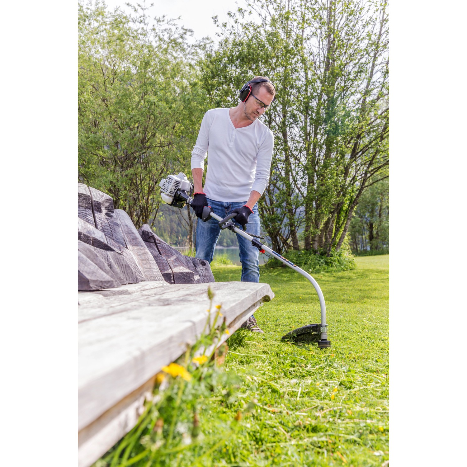 Mann arbeitet mit Al-Ko Benzinmotorsense BC 223 L-S im Garten. Leichte Motorsense für präzises Trimmen.