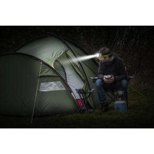Mann mit Energizer Vision HD+ Kopflampe vor Zelt. LED-Taschenlampe mit hellem Licht.