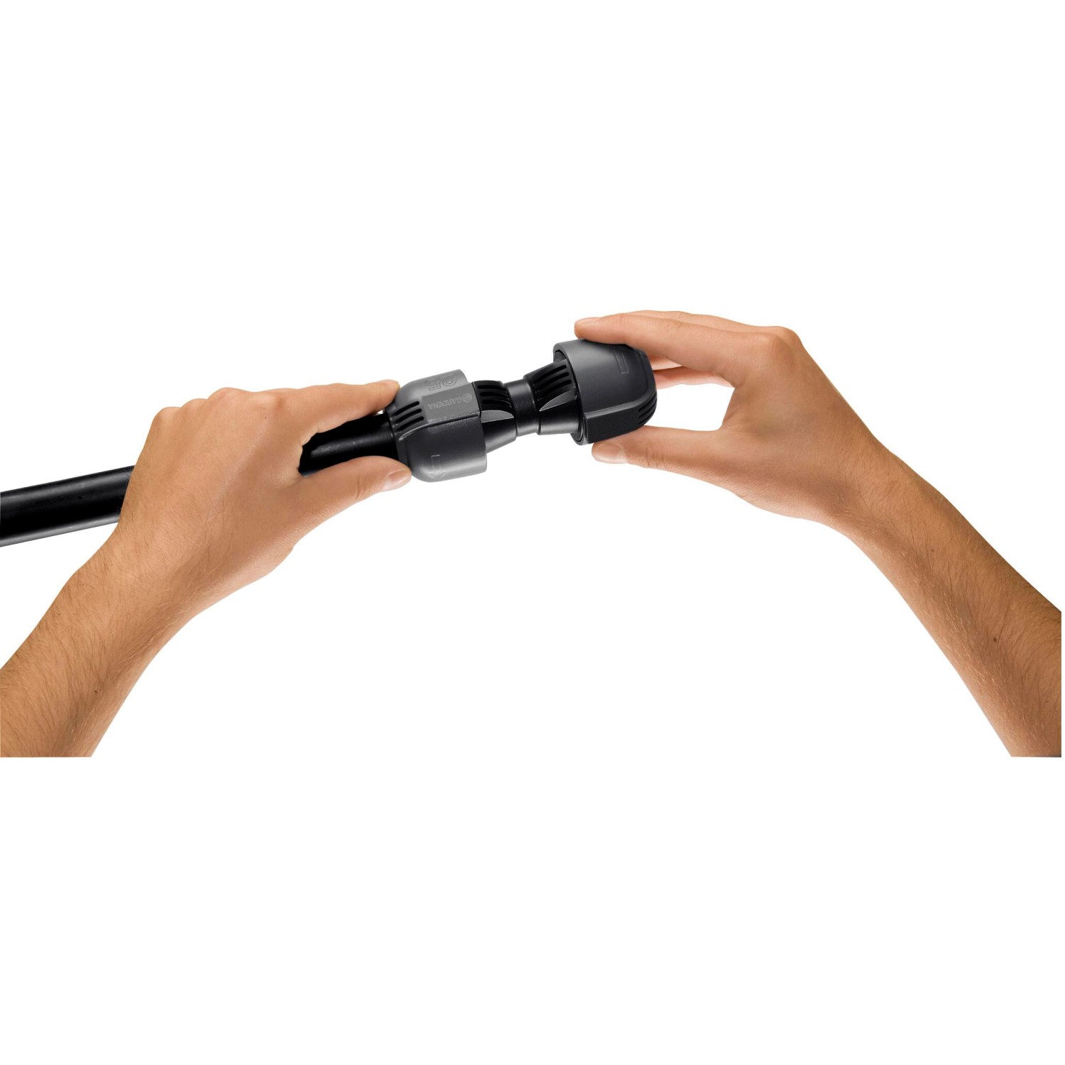 Gardena Verbinder 25 mm im Einsatz: Zwei Hände verbinden ein schwarzes Rohr mit dem Sprinkler-System Verbinder.