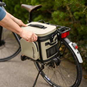 Petromax Kühltasche am Fahrradträger mit Fahrradgurt in Schwarz befestigt.