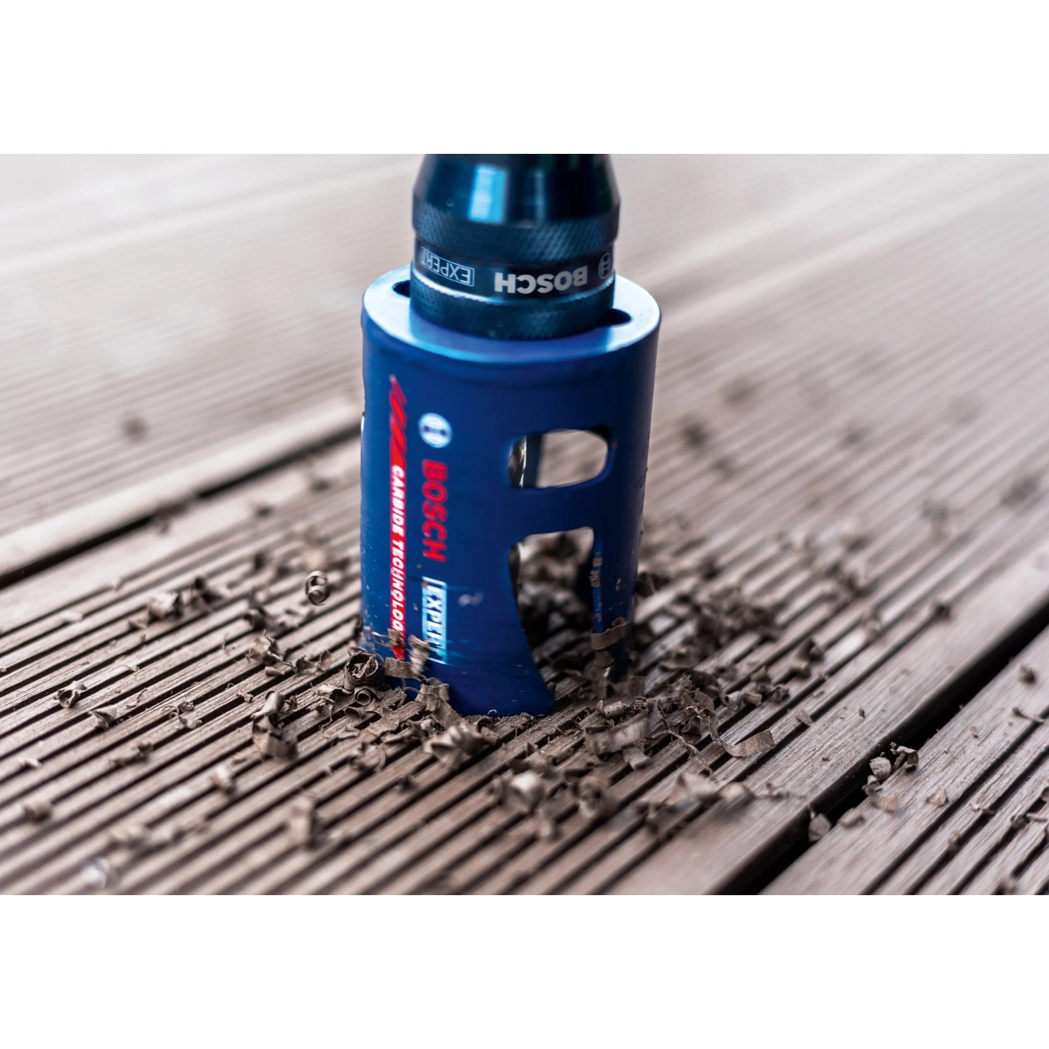 Bosch Expert Lochsäge (Ø 40 mm) beim Bohren in Holz, mit Holzspänen.