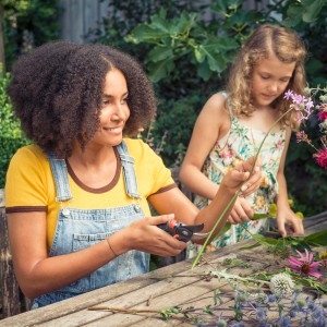 Frau schneidet Blumen mit Gardena Gartenschere Comfort B/S-XL. Präzise Blumenschere für Gartenarbeit.