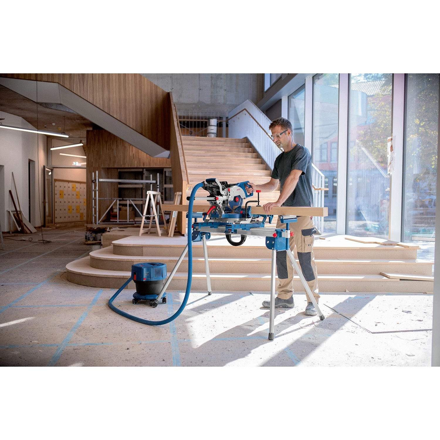 Bosch Professional Akku-Kapp- und Gehrungssäge GCM 18 V-216 DC im Einsatz mit Staubabsaugung.