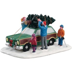 Lemax Weihnachtsdekoration: Familie transportiert Weihnachtsbaum auf Autodach.