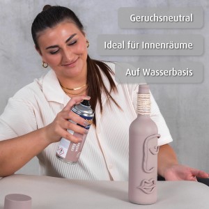 Frau sprüht belton Buntlack Cosy Velvet seidenmatt auf Deko-Flasche.