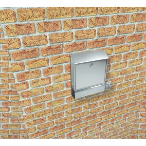 Edelstahl Briefkasten mit Zeitungsfach an einer Backsteinwand.