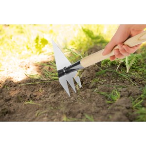 Ruwi Multi-Handharke 8in1 aus Edelstahl im Einsatz beim Jäten im Garten.