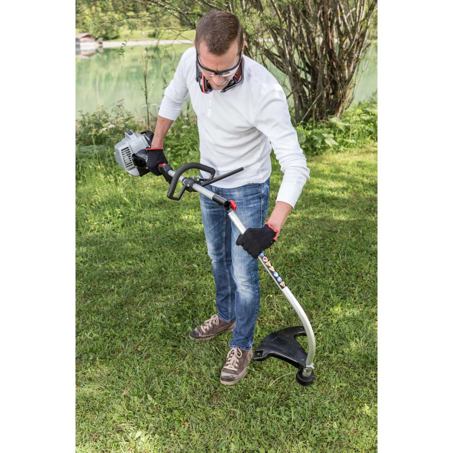 Al-Ko Benzinmotorsense BC 223 L-S im Einsatz: Mann mäht Gras mit dem Freischneider im Garten.