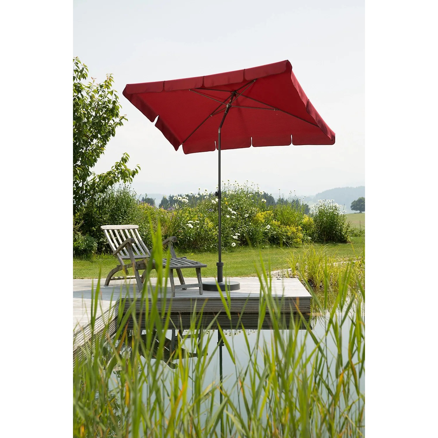Dunkelroter Schneider Balkonschirm Aquila 225x120 cm mit Push-Up Mechanik auf Terrasse am Wasser.