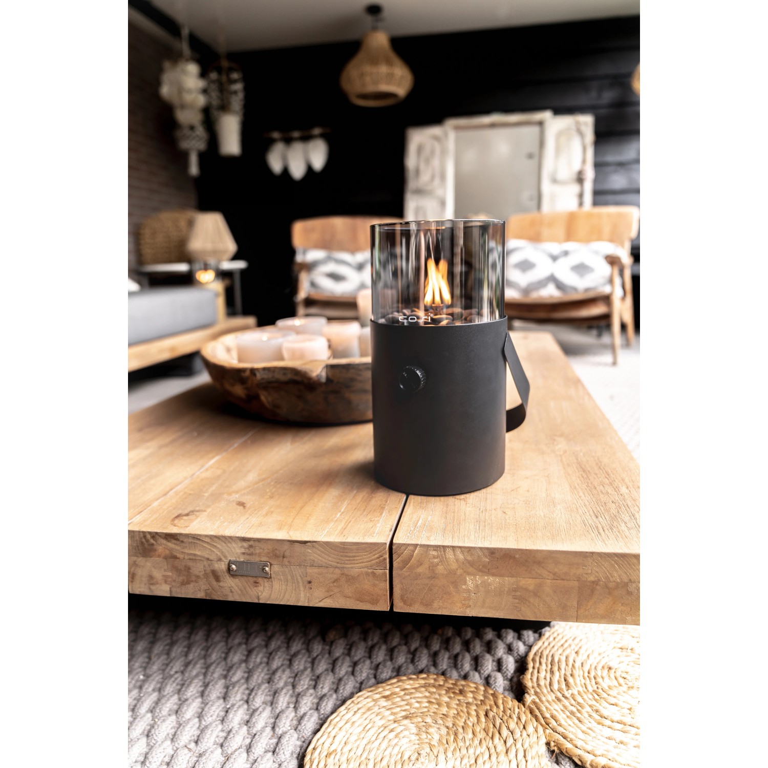 Schwarze Cosi Gaslaterne Cosiscoop Original mit Rauchglas auf Holztisch. Terrassenheizer mit Tragegriff.