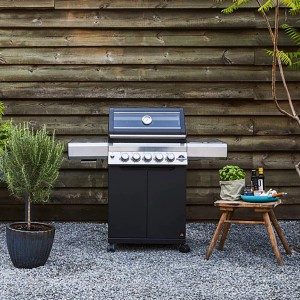 Schwarzer Jamestown 3-Brenner Gasgrill Knox mit Seitenbrenner und Glasdeckel vor Holzwand.