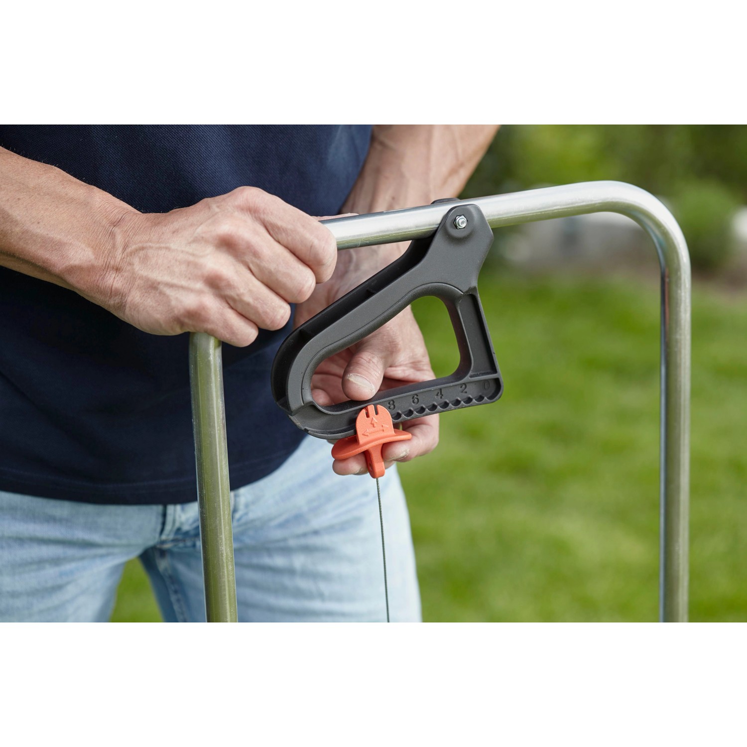 Detailaufnahme: Hand bedient Gardena Streuwagen L zur Dosierung von Saatgut oder Dünger.